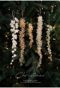 Gros plan de glaçons en acrylique et perles suspendus sur un sapin de Noël illuminé