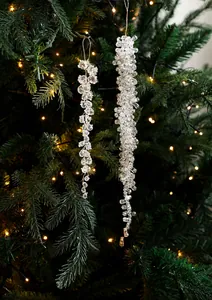 Glaçons de Noël en acrylique transparent sur branche avec lumières festives chaudes