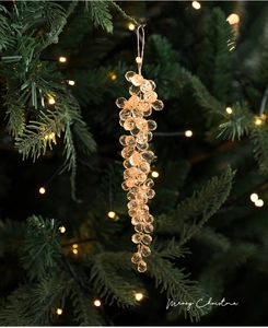 Gros plan de grappes de perles de cristal champagne suspendues à un sapin de Noël