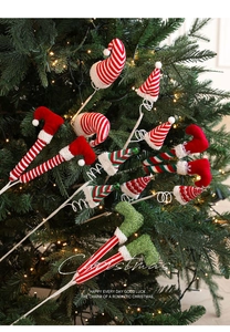 Detail van kerstelfenpoten en hoeden versierd op een feestelijke verlichte kerstboom