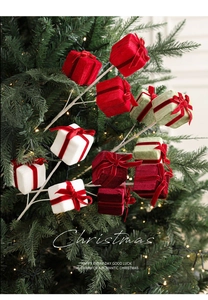 Close-up of velvet Christmas gift box branch inserted in a festive lighted Christmas tree