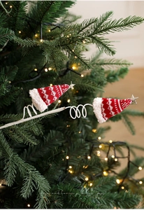 Detail van kerstboomstokjes met rode gebreide mutsen en zilveren sterren op spiraalstelen