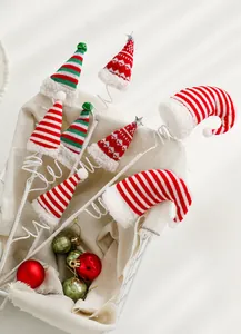 Primer plano de palillos navideños decorativos con mini gorros de Papá Noel de peluche.