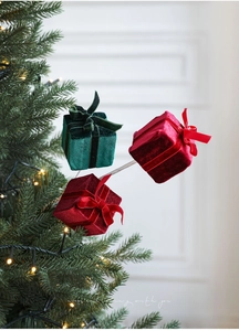 Close-up of velvet Christmas gift box ornaments with ribbon bows on a decorated tree