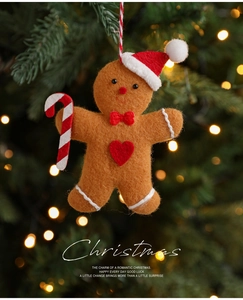 Gingerbread man hanging ornament on Christmas tree with warm bokeh light background