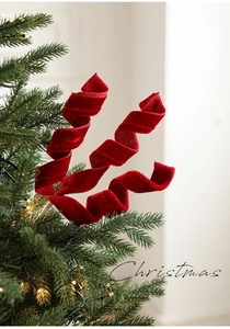 Dettaglio decorazione a spirale in velluto rosso su albero di Natale con luci