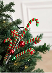 Close-up of red and green spiral candy cane picks with festive bulbs on a Christmas tree