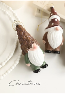 Detail of two handmade Christmas gnome ornaments with pointed hats and soft white beards