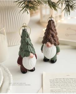 Detail of resin Christmas gnomes with green tree and pine cone hats on festive tabletop