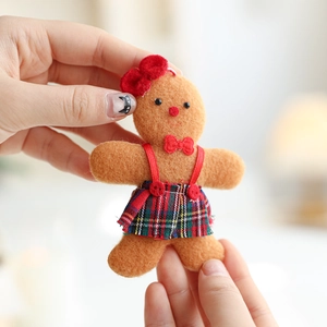 Brown gingerbread man plush ornament with red bow and plaid skirt for Christmas tree decor