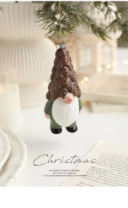 Detail view of a gnome Christmas ornament with white beard and gold hanging string