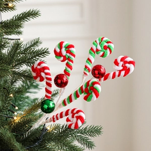 Plush candy cane and gingerbread ornaments on a Christmas tree branch with ornaments