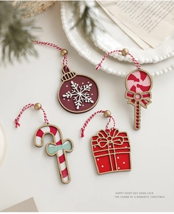Close-up of painted wooden Christmas tree ornaments with festive red and white hanging cords