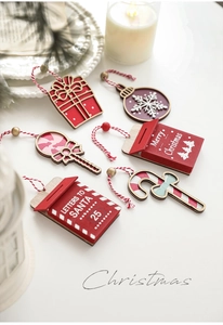 Detail of red and white Christmas wooden ornaments with festive patterns and hanging ropes