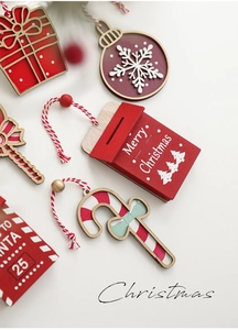 Set of festive red and white wooden Christmas tree ornaments with snowflakes and hanging tags