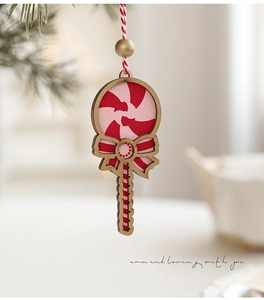Macro shot of candy-shaped wooden Christmas ornament with red stripes and bow