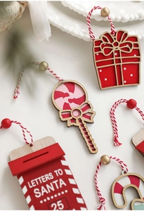 Macro detail of wooden Christmas ornaments including Santa letters mailbox and candy canes