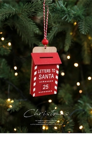 Detail of red wooden Santa letter mailbox ornament hanging on green pine branch