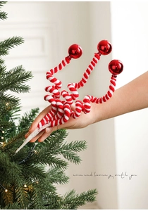 Detail of red and white spiral plush candy cane sticks with shiny balls on a Christmas tree