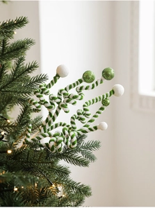 Detail of green and white spiral Christmas stems with glitter ornaments on a tree