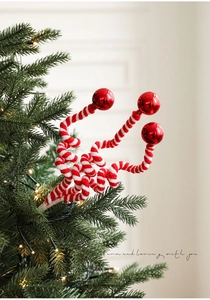 Detail of red and white striped candy cane Christmas picks with glossy red ornaments