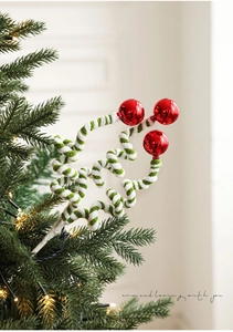 Detail of red mirror balls on green and white spiral plush stems for Christmas tree decor