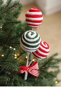 Macro detail of striped plush Christmas picks with bow tie on a lit Christmas tree