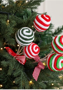 Close-up of spiral lollipop Christmas tree picks with festive red and green plaid bows