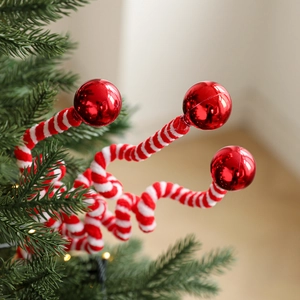 Red and white striped Christmas candy cane plush ornament on a Christmas tree