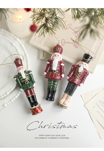 Three colorful plastic nutcracker soldier ornaments on a pine branch for Christmas