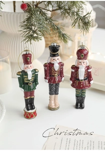 Three festive nutcracker soldier ornaments in red and green for Christmas tree decor