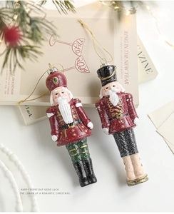 Detail of colorful nutcracker soldier ornaments with gold strings on a Christmas tree