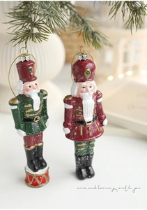 Close-up of hand-painted Nutcracker soldier Christmas ornaments with festive gold hanging strings