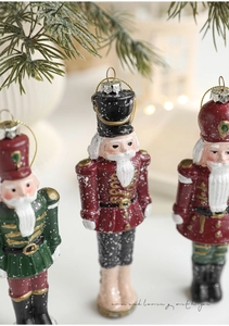 Detail of colorful nutcracker soldier ornaments with gold glitter and hanging strings