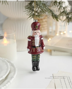 Detailed view of nutcracker soldier ornament with glitter on a festive pine branch
