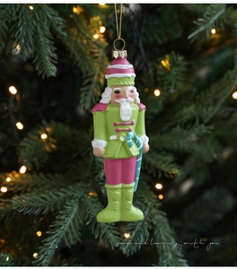 Detail of colorful nutcracker soldier ornament with candy cane on a festive Christmas tree