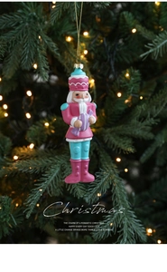Close-up of pastel nutcracker ornament with pink and blue details on a Christmas tree