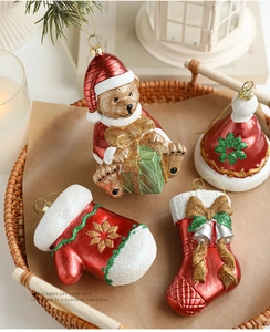 Macro shot of glittery Christmas ornaments including bear and stocking in a rustic tray