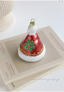 Detail of red metallic Christmas hat ornament with green glitter flower and gold trim