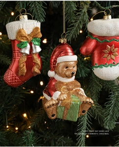 Detail of Christmas tree ornaments featuring red socks, bears, and gloves on tree branches