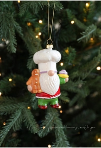 Detailed view of chef gnome ornament holding gingerbread man for Christmas tree decor