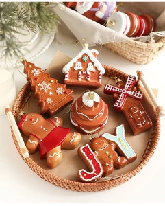 Detailed view of six gingerbread-style Christmas ornaments in a woven tray setup