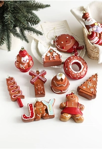 Detail of resin gingerbread man and festive Christmas tree ornaments with gold hooks