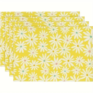 Détail de la texture en lin et de l'imprimé marguerite jaune sur un lot de quatre sets