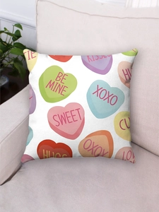 Detail of pink Valentine conversation hearts plush pillowcase on a beige sofa