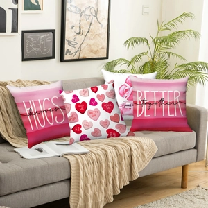 Set of 4 pink Valentine's Day pillow covers with heart patterns on a gray fabric sofa