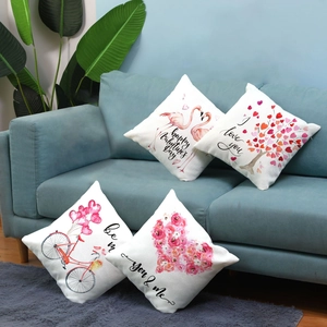 Set of four Valentine's Day plush pillow covers with flamingo and heart patterns on sofa