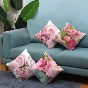 Detail of four floral throw pillows on a blue sofa featuring pink rose designs and Paris text