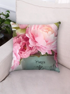Detail of pink floral plush pillowcase featuring PARIS text on a soft cream sofa
