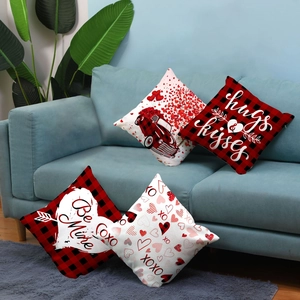 Detail of four Valentine red buffalo plaid pillow covers displayed on a blue fabric sofa